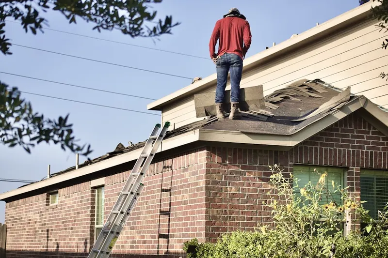 Professional roofer working on a residential roof in Thelma